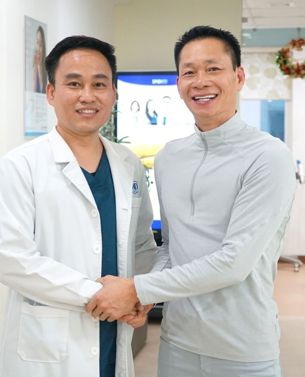 Hình ảnh anh Lệ chụp cùng bác sĩ Trần Hưng sau khi hoàn thành bộ răng mới