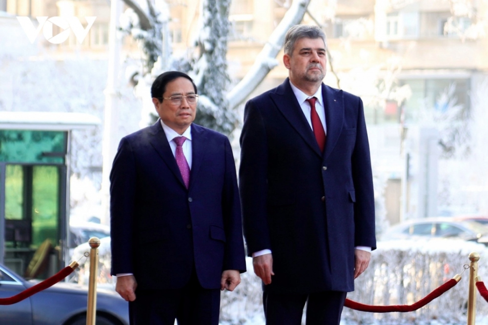 Romanian Prime Minister Ion-Marcel Ciolacu invites Vietnamese counterpart to step on the podium while military bands play the national anthems of both nations.