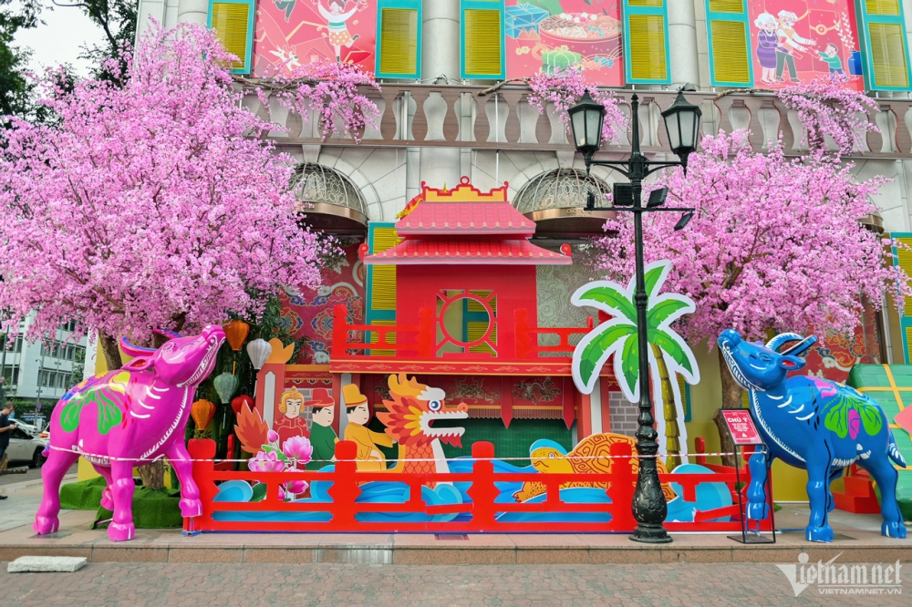 A corner is decorated with images of peach blossoms, the Temple of Literature, and the Tet traditions of the northern region.