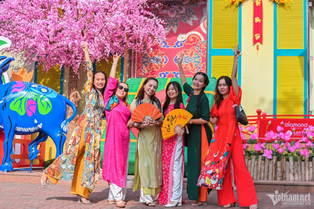 Local women wearing an Ao Dai poses for a group photo to keep Tet memories.