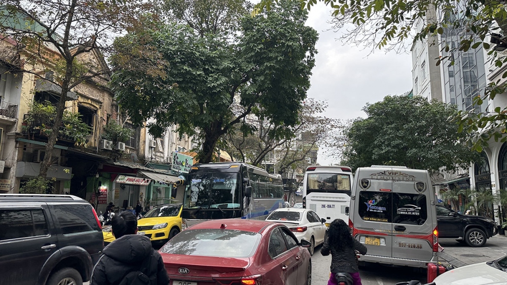 Xe đón trả khách trước một khách sạn ở phố Cửa Đông khiến giao thông ùn ứ.
