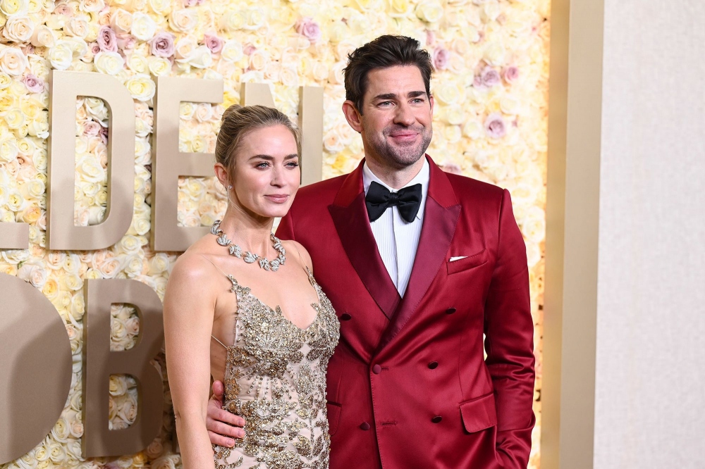Ngôi sao “Oppenheimer” Emily Blunt mặc chiếc váy Alexander McQueen bằng vải tuyn màu vàng và trắng với trang sức Tiffany &amp; Co., trong khi chồng John Krasinski trông táo bạo trong chiếc áo blazer sa tanh màu đỏ và quần tây màu đỏ tía.