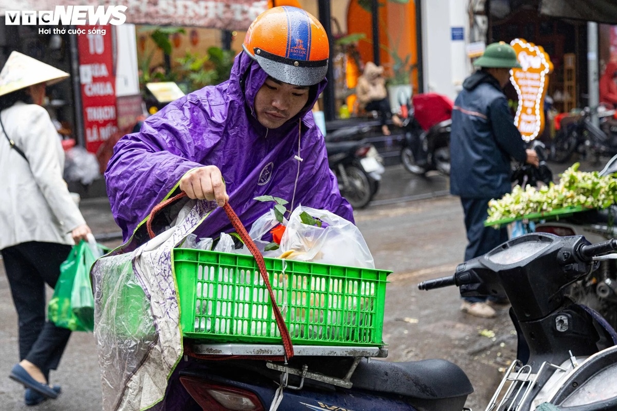 Lực lượng shipper làm việc hết năng suất. "Vì trời mưa lạnh, số khách hàng đặt mua giao hàng tận nhà tăng đột biến", một người giao hàng cho biết.