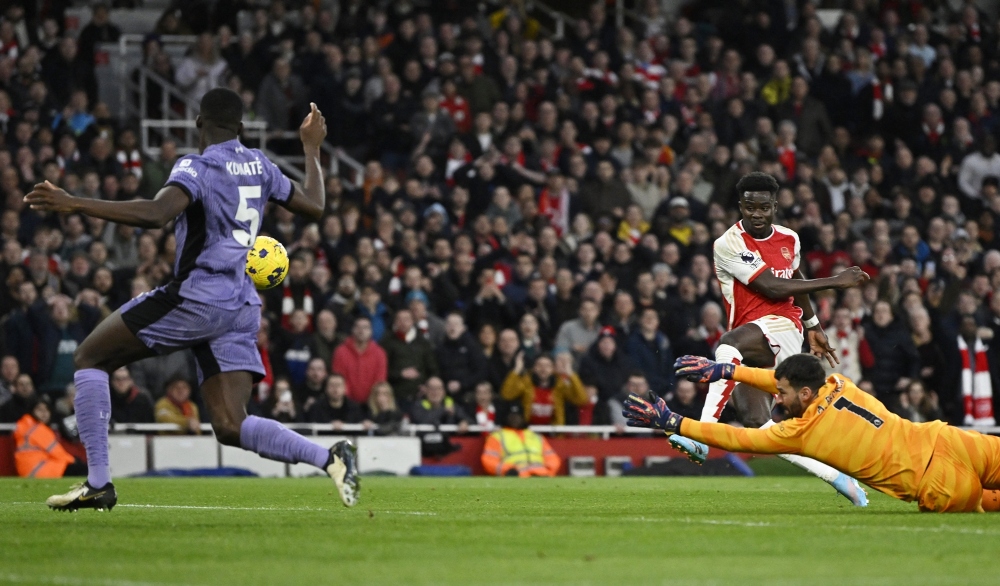 Saka sút bồi tung lưới Liverpool sau khi thủ môn Alisson cản phá cú dứt điểm của Martinelli. (Ảnh: Reuters)