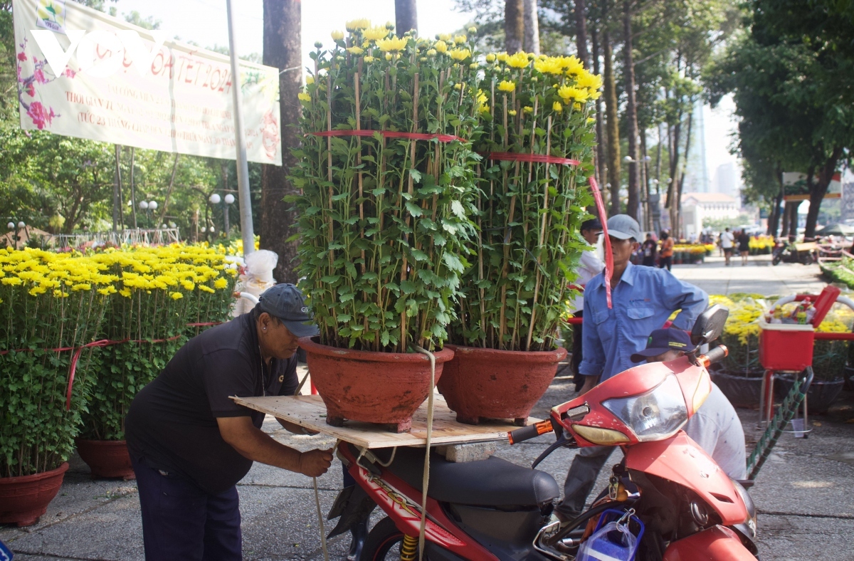 Delivery men are bust loading the flower pots onto their vehicles in order to hand over to their customers.