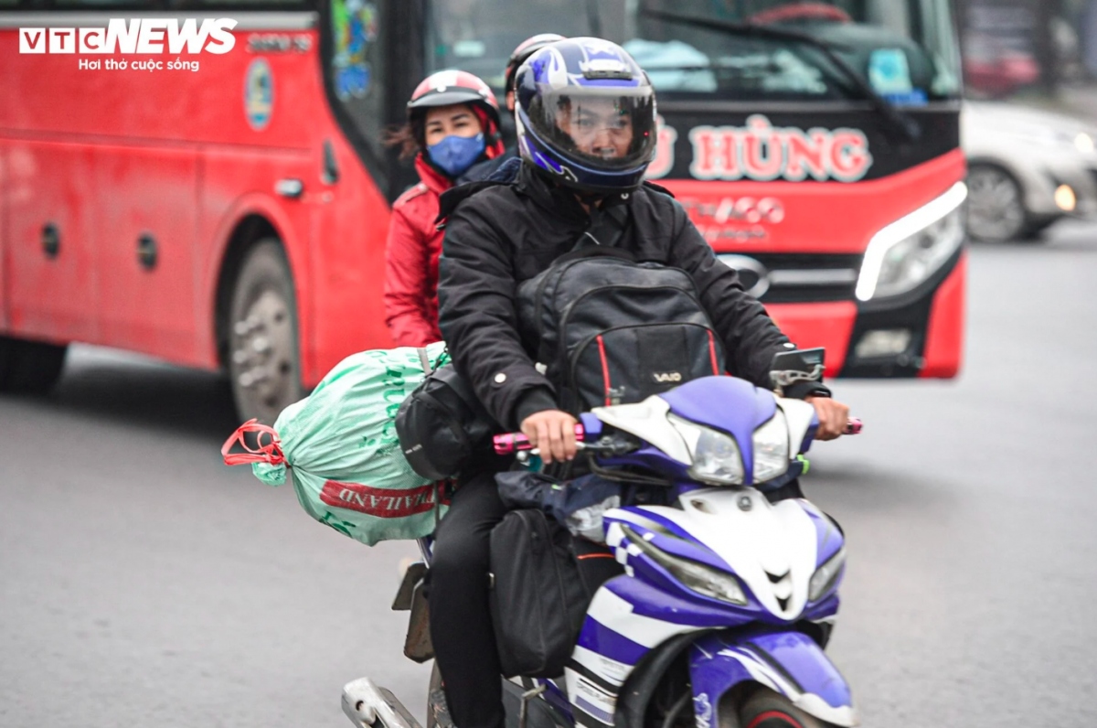 Motorbikes carrying with them personal belongings slowly make their way to these gateways to leave the city.