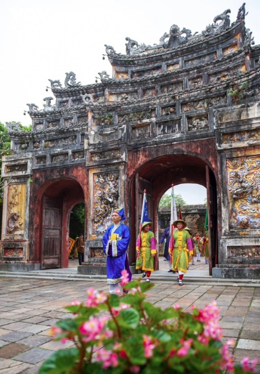 The soldiers are led by people dressed up in mandarin costumes and accompanied by a band of musicians playing royal music.