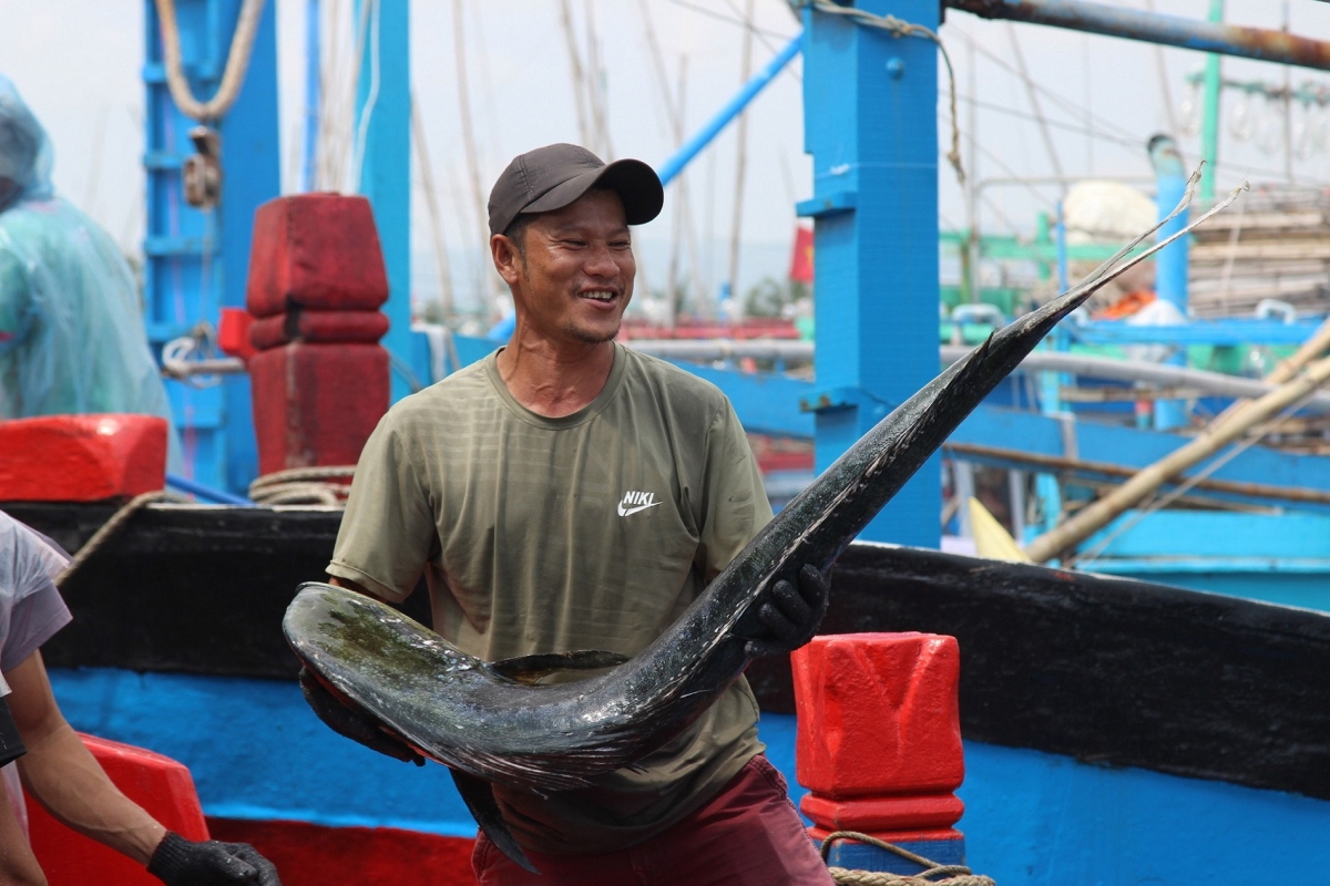 A fisherman is excited to net a big tuna fish.