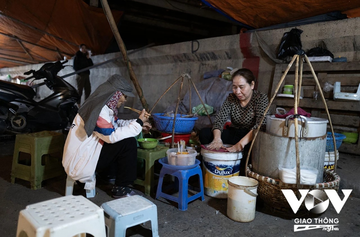 Một bà cụ làm nghề bốc hàng thuê tranh thủ ngồi nghỉ ăn bát bún lúc 1 giờ sáng, và sau đó sẽ tiếp tục công việc của mình tới tận sáng sớm ngày hôm sau