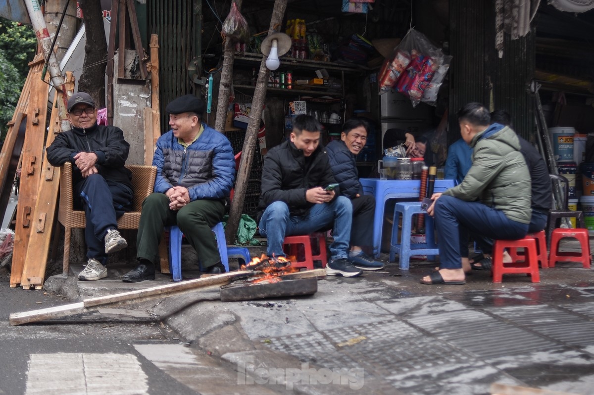 Several people choose to drink hot cups of tea as a means of keeping warm amid the cold air.