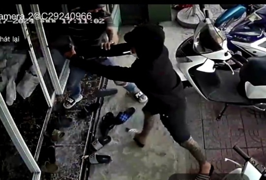 Đối tượng cầm vật đen nghi súng chĩa vào cửa hàng ở TP Tân An (ảnh clip camera)
