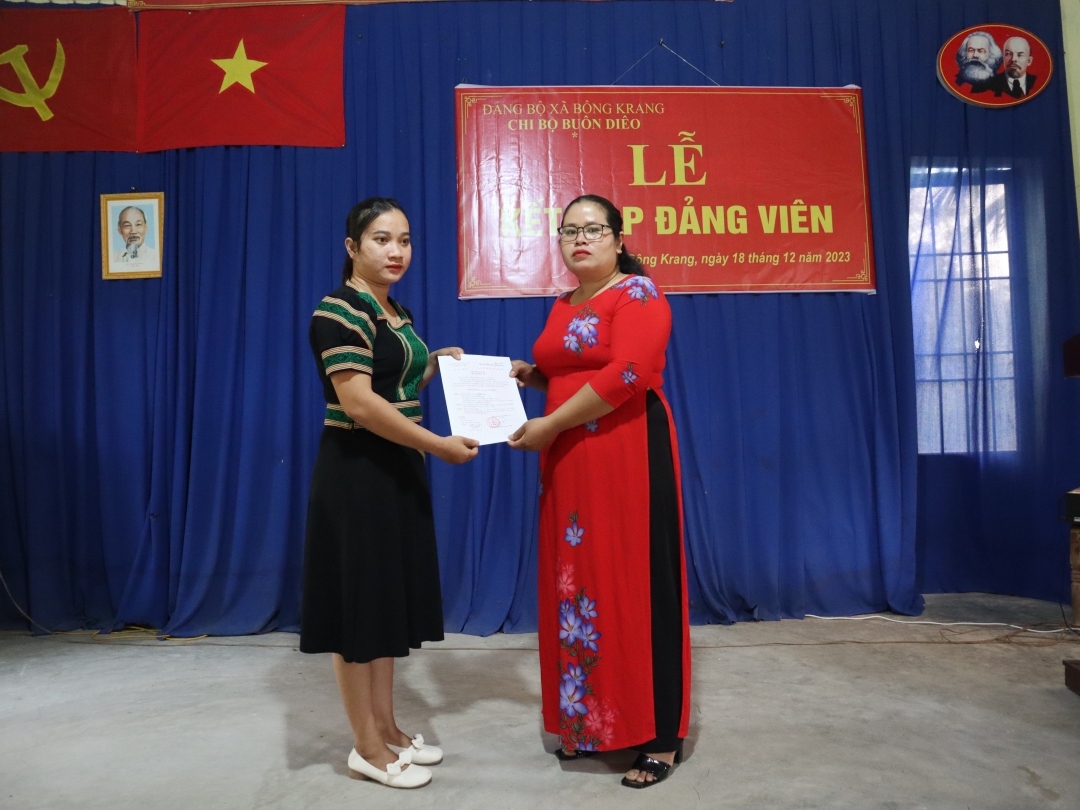 H Mên Teh (bên trái), ở buôn Diêo, xã Bông Krang, huyện Lắk nhận Quyết định kết nạp đảng viên.
