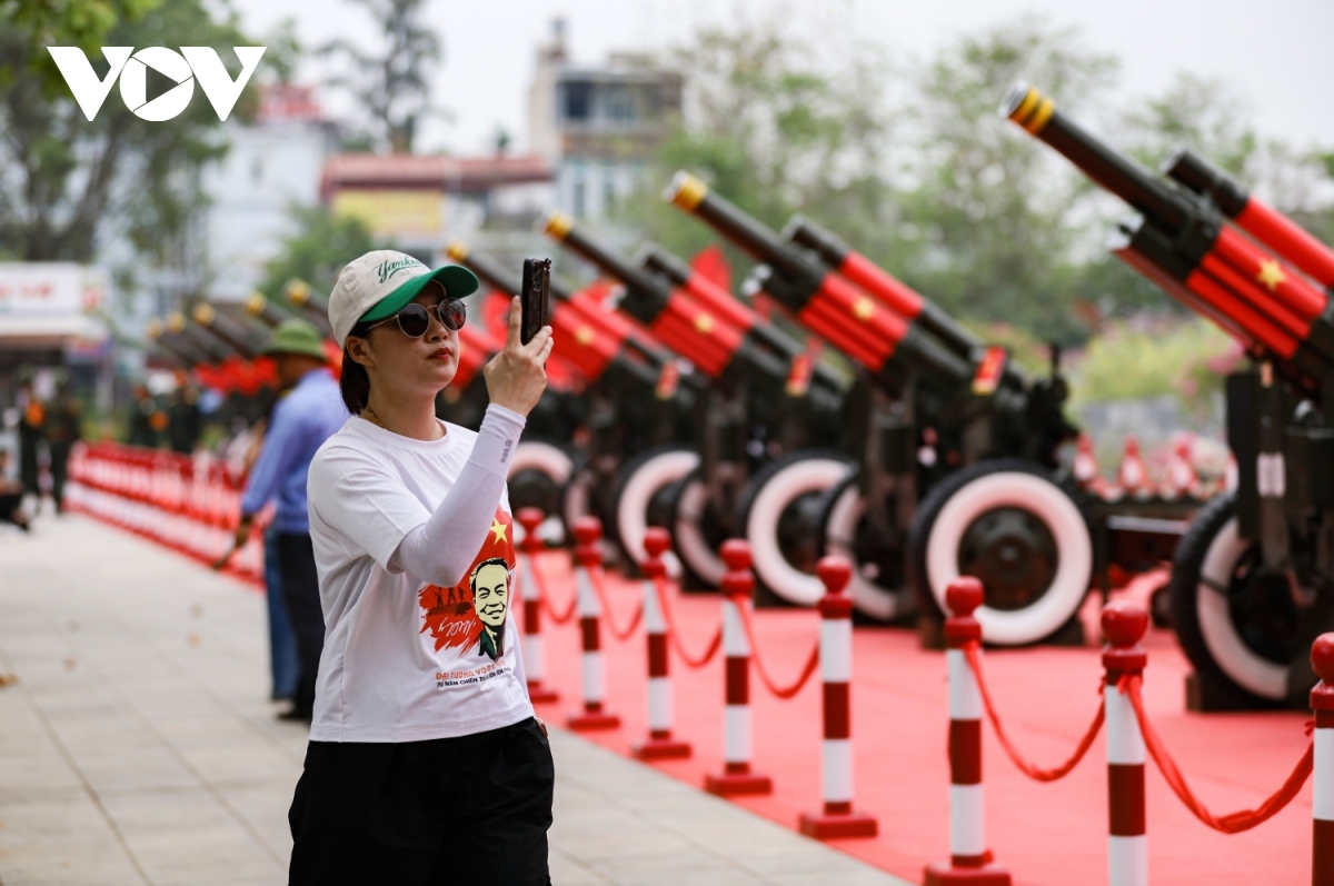 Some viitors are excited at taking photos alongside the artillery.