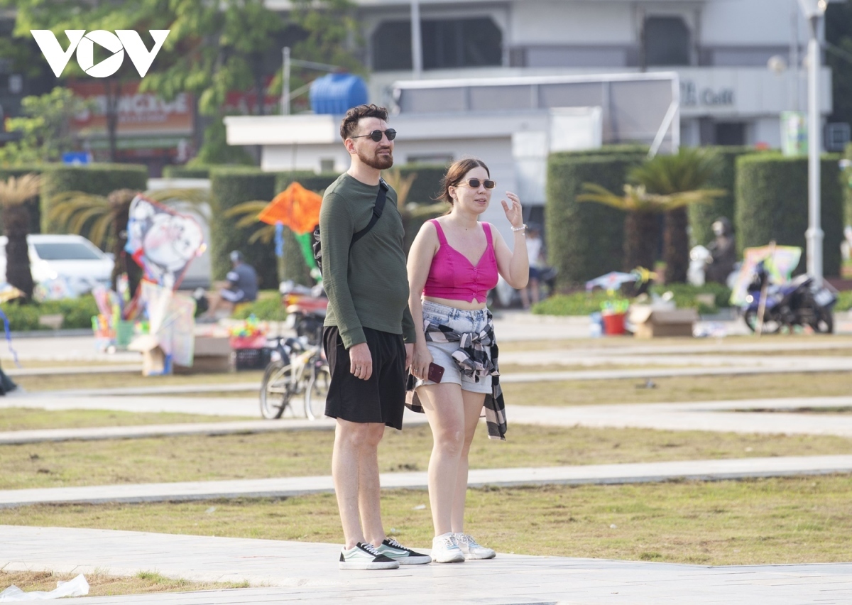 Foreign tourists excitedly admire the colourful kites as they flutter in the sky.