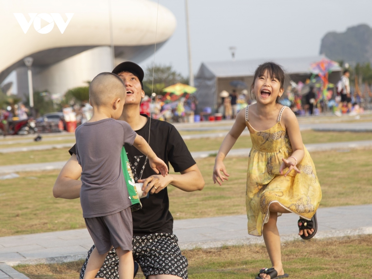 Young children enjoy listening to their parents' instructions on how to fly their kites.
