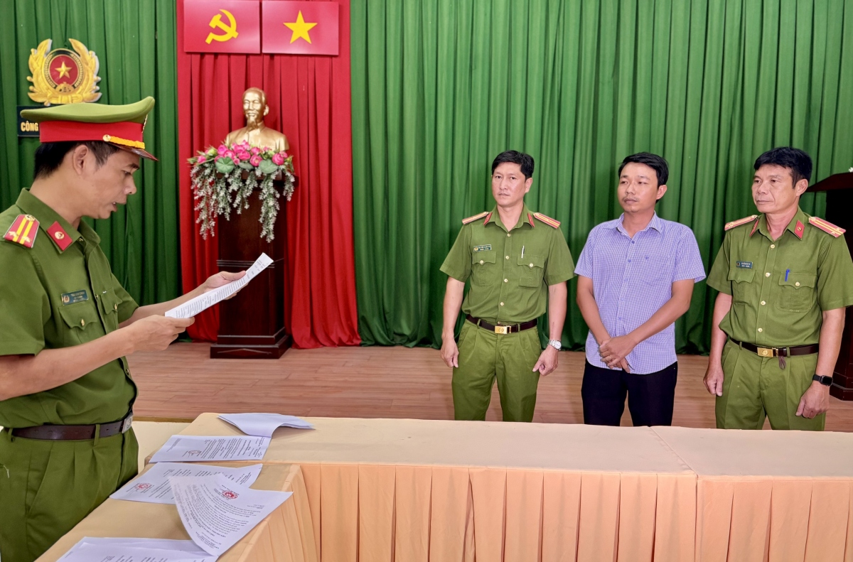 Cơ quan Công an tống đạt các quyết định khởi tố đối với bị can Phạm Quang Vinh ( người đứng giữa hai cán bộ Công an).