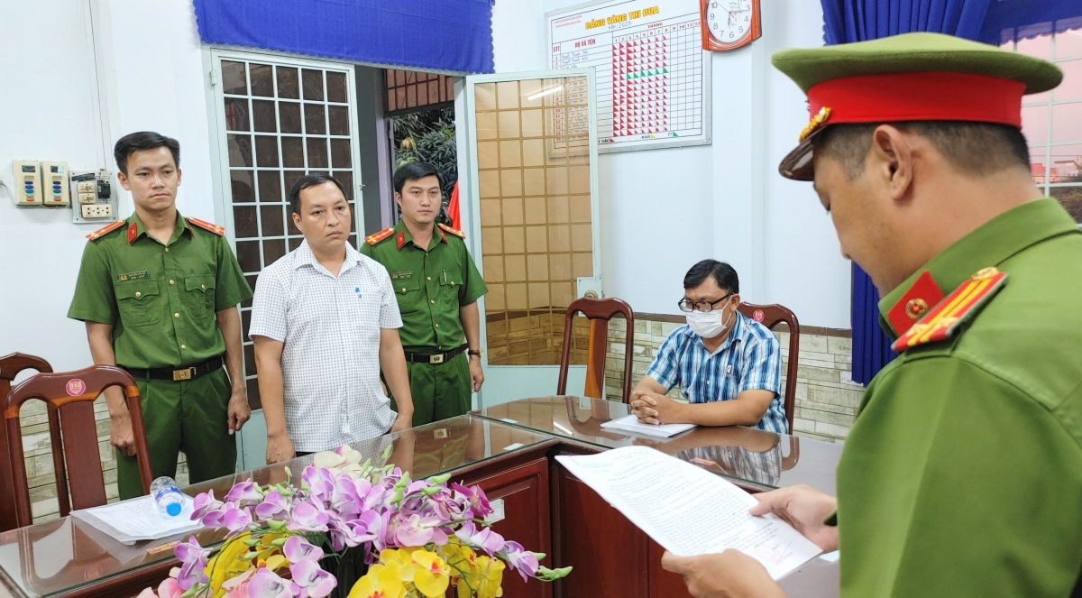 Cơ quan Công an đang tống đạt các quyết định khởi tố đối với bị can Ngô Hồng Việt Chương (người đứng giữa hai cán bộ Công an).