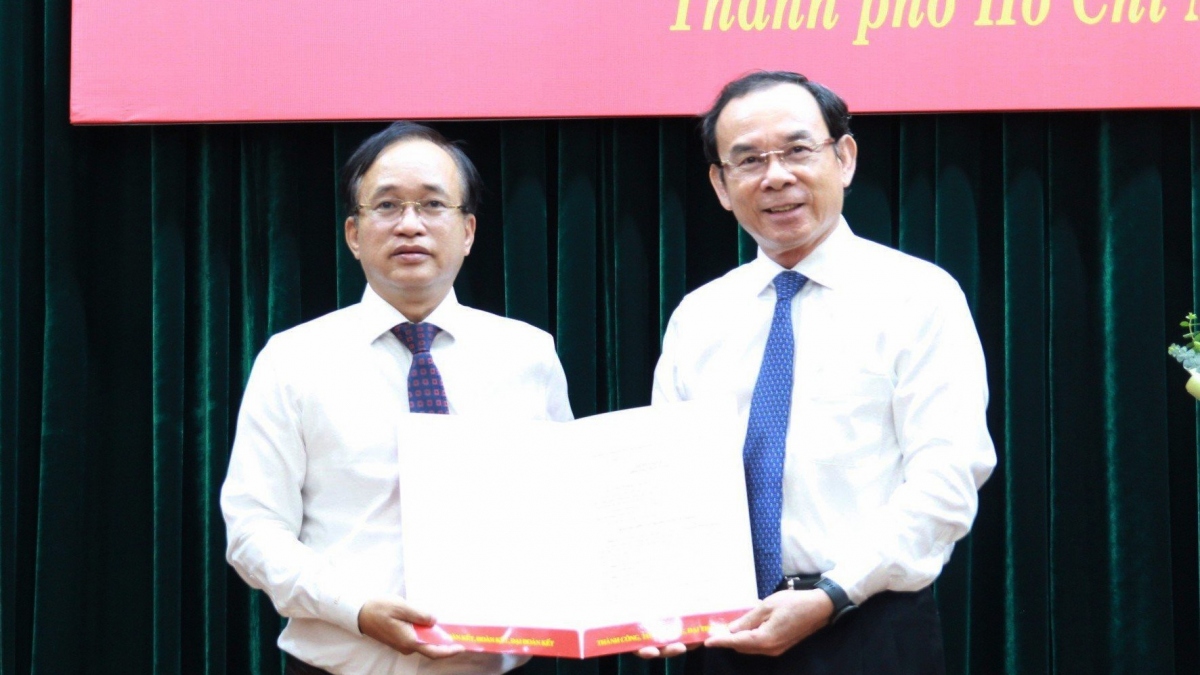 Bí thư Thành ủy TP.HCM Nguyễn Văn Nên (phải) trao quyết định cho ông Nguyễn Phước Hưng (ảnh: A.H)