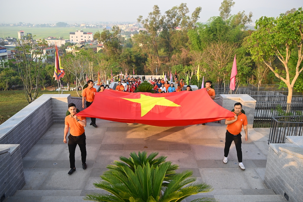 Cán bộ nhân viên FPT rước cờ Tổ quốc vào Đền thờ Liệt sĩ tại chiến trường Điện Biên Phủ (Ảnh: Giang Huy)