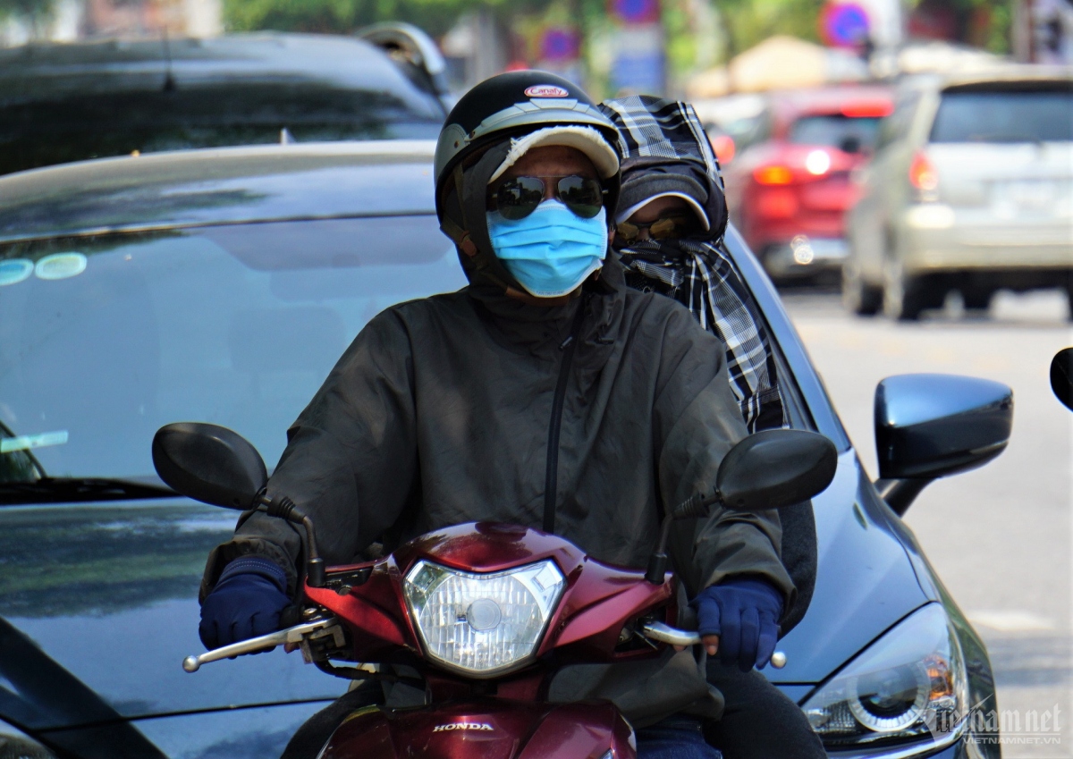 Drivers wear long clothing, masks, and sunglasses to cope with the scorching heat in Da Nang.