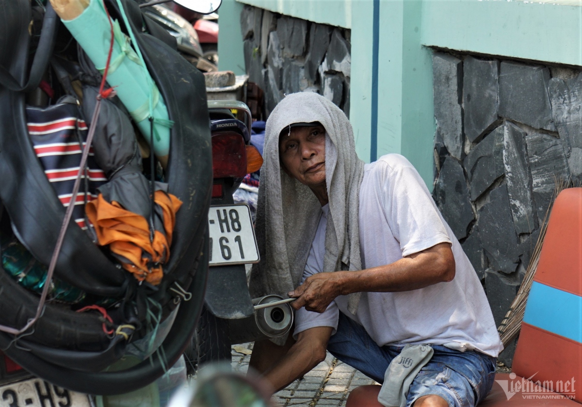 A worker brings along a wet towel in an attempt to cool down amid the hot weather.