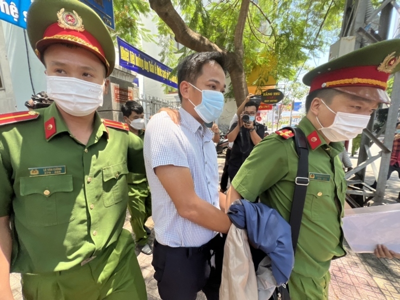 Ông Trần Quốc Huy, cán bộ CDC Khánh Hòa bị bắt, Công an dẫn giải ra khỏi nơi làm việc.