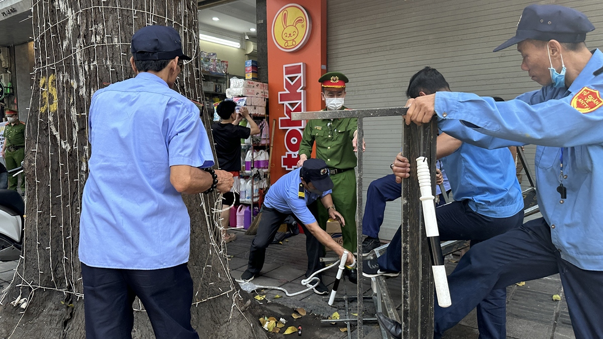 Tháo dỡ bục bệ, đèn trang trí người dân cuốn xung quanh các thân cây sao đen.