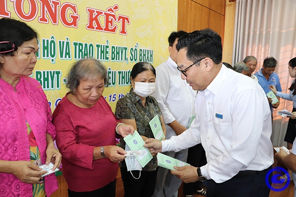 Ông Võ Khánh Bình, Giám đốc Bảo hiểm xã hội tỉnh Tiền Giang trao tặng thẻ bảo hiểm y tế cho người dân.