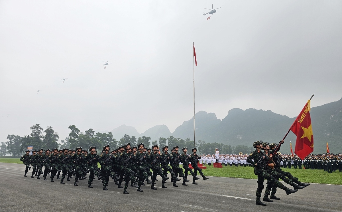 Biên đội trực thăng thuộc Quân chủng Phòng không không quân mang theo cờ Đảng, cờ Tổ quốc bay trong buổi tổng tuyển và Khối chiến sĩ đặc nhiệm đang tiến vào lễ đài.