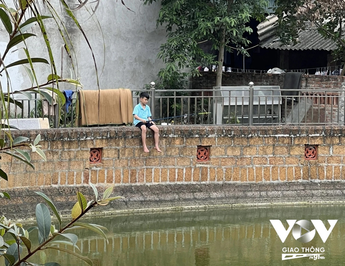 Hình ảnh rất làng quê giữa trưa hè, em nhỏ ngồi câu cá