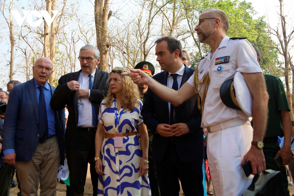 The French Defense Minister and former French war veterans listen to an introduction to the historical site Hill A1.