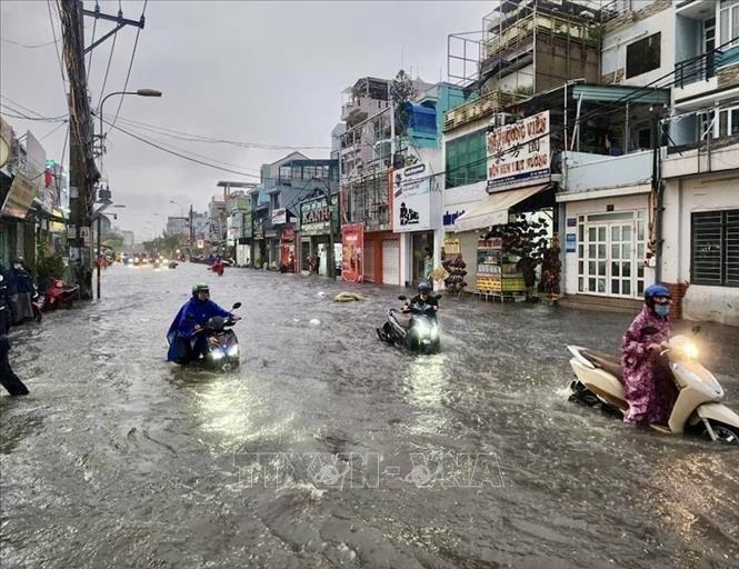 Nước ngập lút bánh xe mô tô trên đường Kha Vạn Cân (thành phố Thủ Đức, Thành phố Hồ Chí Minh). Ảnh: Hồng Giang/TTXVN.