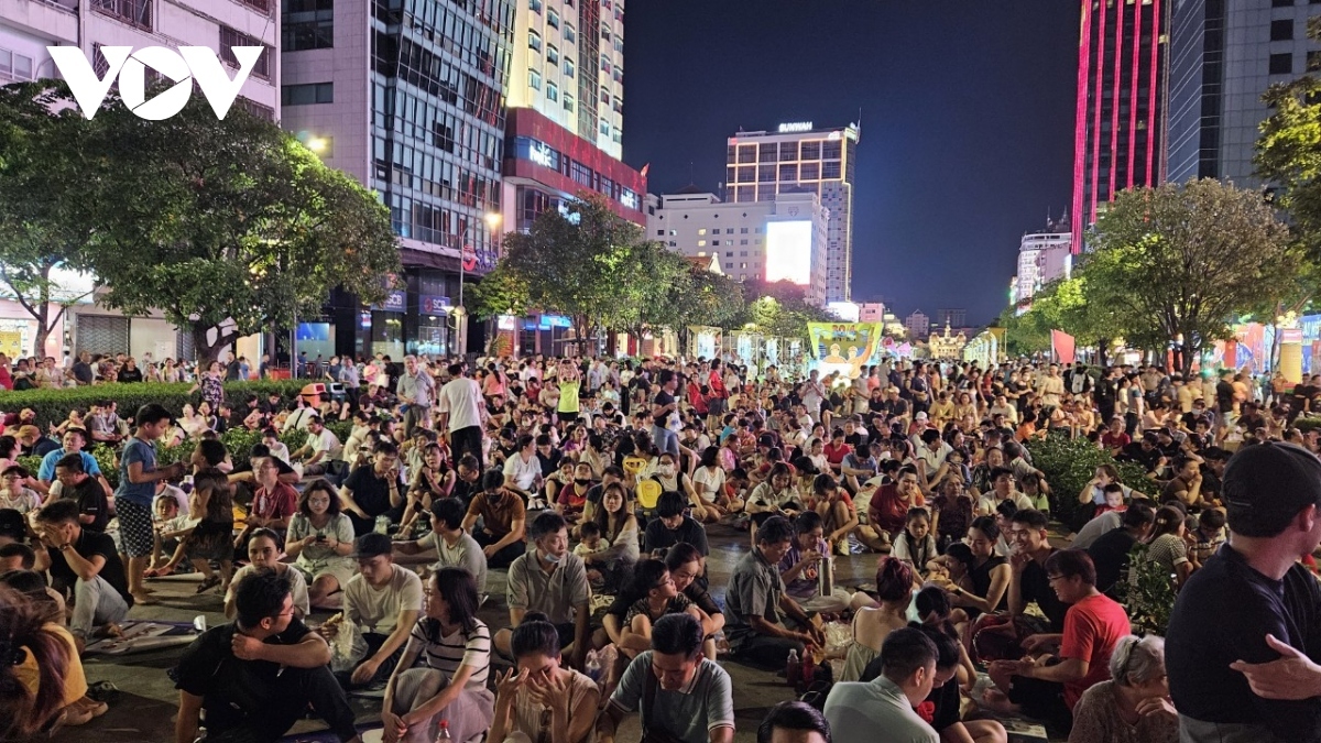 Crowds of revelers eagerly wait for the fireworks show along the banks of Saigon River.