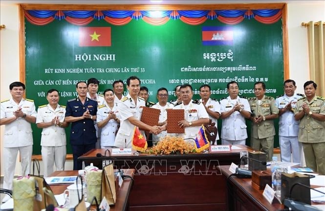 Chuẩn Đô đốc Nguyễn Hữu Thoan và Phó Đô đốc Mey Dina trao biên bản ghi nhớ phối hợp công tác trong thời gian tới. Ảnh: TTXVN