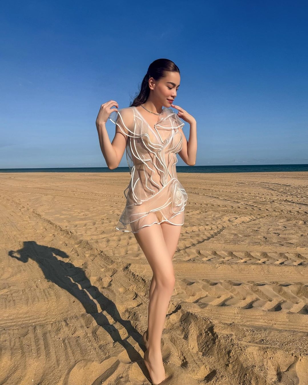 Trong chuyến đi nghỉ dưỡng hồi tháng 4, Hồ Ngọc Hà chọn váy xuyên thấu ngắn khi đi dạo trên bờ cát. Thiết kế làm từ vải voan trong suốt, lót vải nude mỏng bên trong, giúp cô gợi cảm mà vẫn kín đáo. Gần đây, bà mẹ ba con thường xuyên chọn chất liệu nửa kín nửa hở.