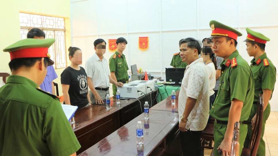 Công bố quyết định khởi tố bị can và lệnh bắt bị can để tạm giam đối với Nguyễn Hữu Hóa (áo trắng bên phải). (Ảnh: CACC)