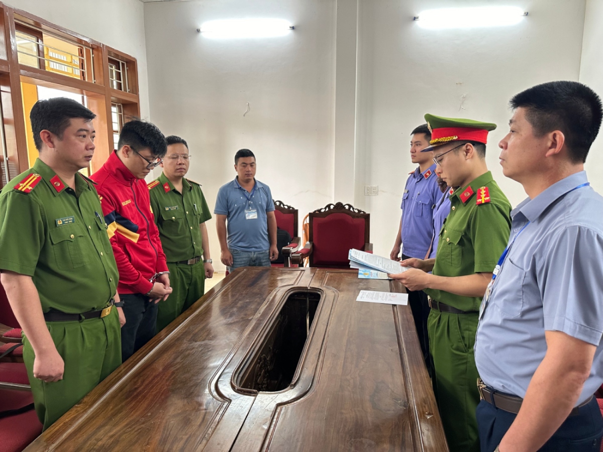 Cơ quan CSĐT Công an tỉnh Sơn La thi hành các quyết định tố tụng đối với Lò Minh Phương (áo đỏ)