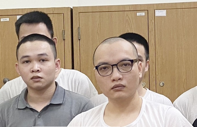 Hoàng Duy Hưng (bên phải) và các đồng phạm tại cơ quan công an. (Ảnh: Công an cung cấp)