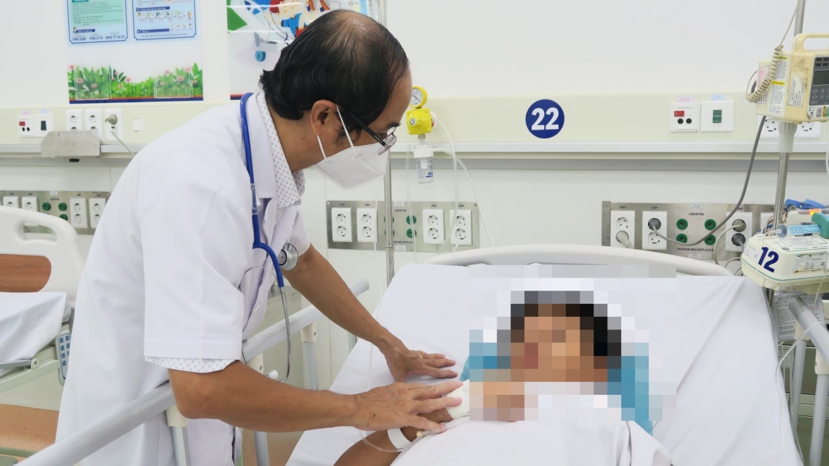PGS-TS-BS Phạm Văn Quang, Trưởng khoa hồi sức tích cực chống độc, Bệnh viện Nhi đồng 1 TP.HCM thăm khám cho bệnh nhi 13 tuổi (Ảnh Đ.H)