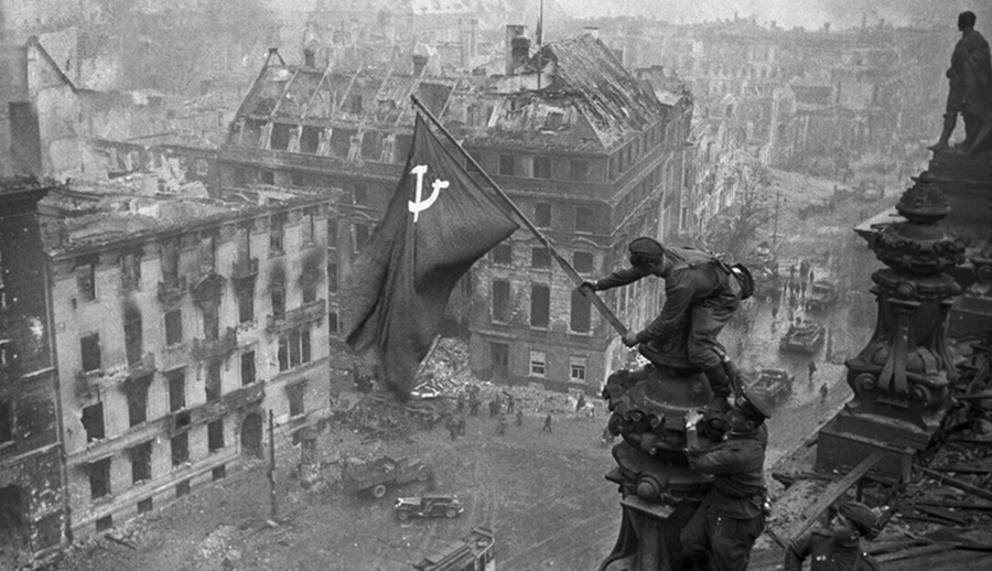 Chiến sĩ Hồng quân phất quân kỳ Chiến thắng trên nóc tòa nhà Reichstag. Ảnh: Sputnik.