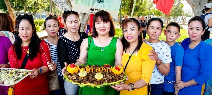 Các chị em chụp ảnh lưu niệm trước gian hàng đồ ăn của Việt Nam.