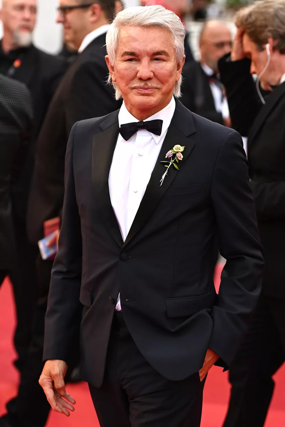 Đạo diễn Baz Luhrmann diện bộ tuxedo cổ điển, có cài phụ kiện hoa trên thảm đỏ Mad Max.