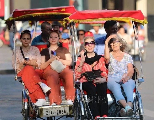 Foreign visitors take a cyclo tour around Hanoi's Old Quarter.