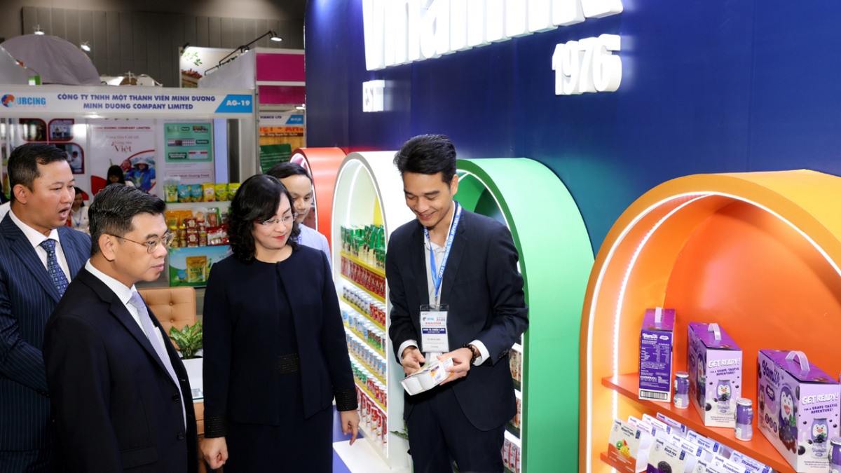 Ông Võ Trung Hiếu giới thiệu các sản phẩm xuất khẩu của Vinamilk với bà Phan Thị Thắng, Thứ trưởng Bộ Công Thương cùng các đại biểu tham quan triển lãm