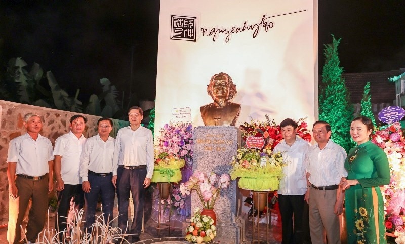 Các đại biểu cùng thân nhân gia đình nhạc sĩ Nguyễn Trọng Tạo chụp hình lưu niệm trước tượng chân dung ông, trong khuôn viên Khu tưởng niệm. Ảnh: Xuân Thuỷ