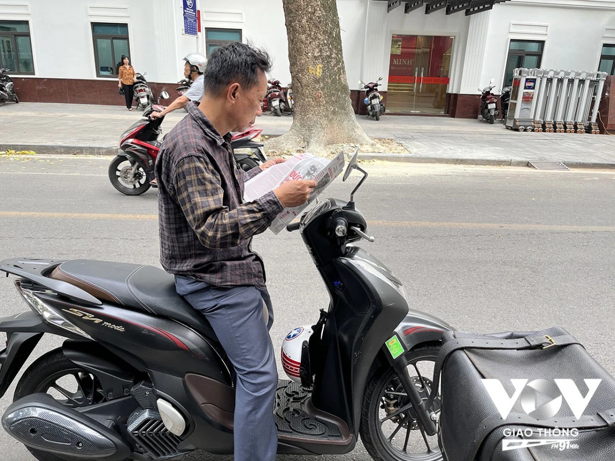 Một fan hâm mộ bóng đá dừng chân mua báo tại một sạp báo trên phố Phan Chu Trinh. Một trong những sạp báo hiếm hoi còn lại trên phố phường Thủ đô