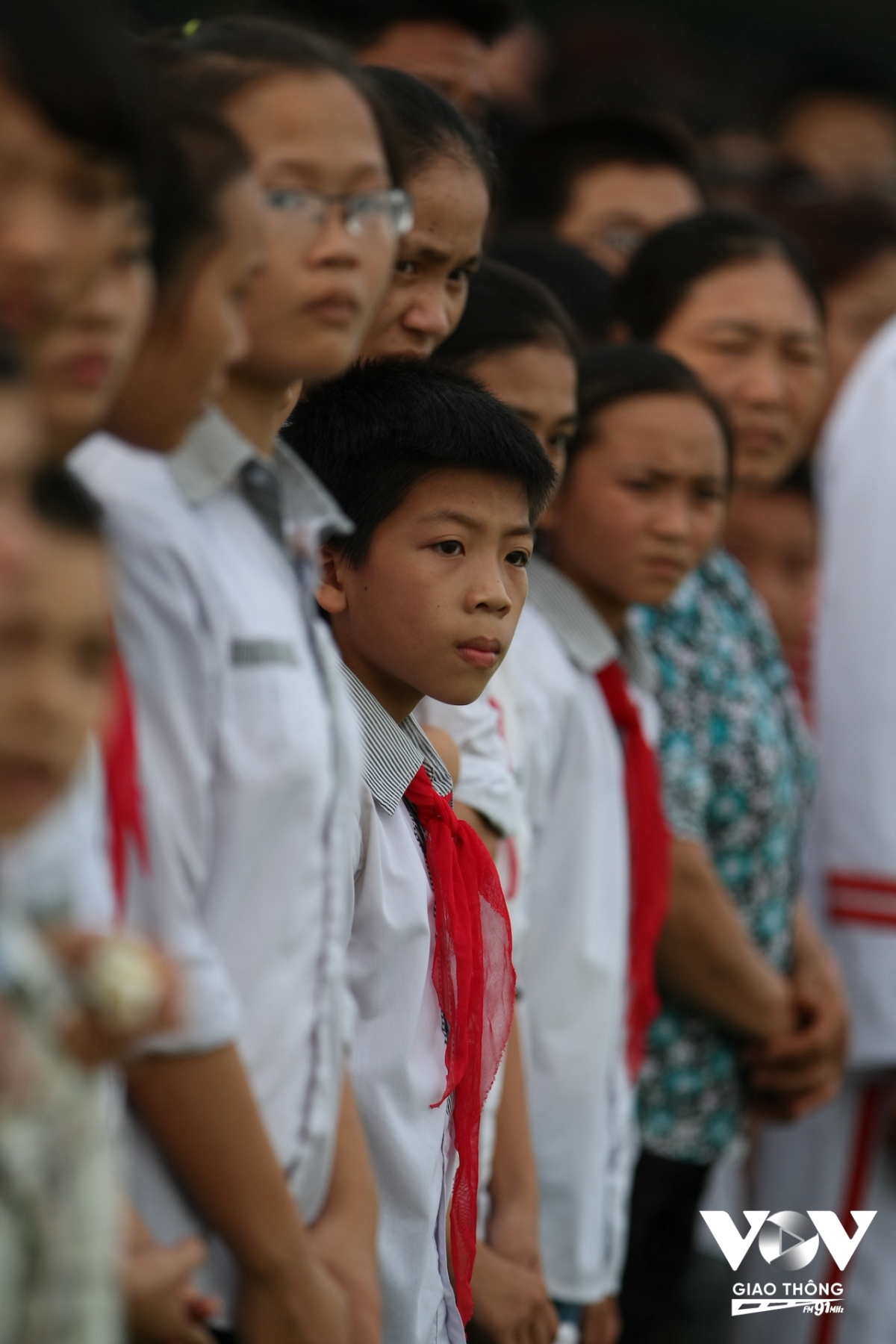 Cậu bé chăm chú đứng chờ lễ thượng cờ sáng sớm trước Lăng Bác trong lần đầu tiên được ra thăm Thủ đô