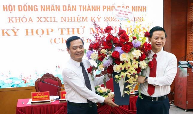 Phó Chủ tịch Thường trực UBND tỉnh Bắc Ninh Vương Quốc Tuấn (bên phải) tặng hoa chúc mừng ông Nguyễn Mạnh Hiếu