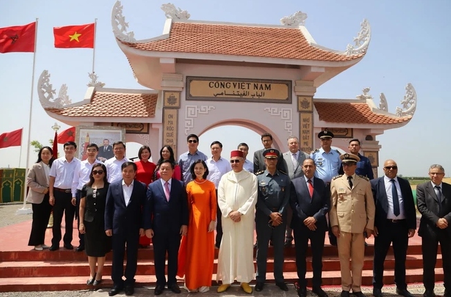 Đoàn đại biểu Đảng Cộng sản Việt Nam chụp ảnh lưu niệm cùng các lãnh đạo địa phương xung quanh Làng Việt Nam tại Maroc tại Cổng Việt Nam tại Maroc. (Ảnh: Hồng Minh/TTXVN)