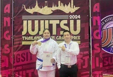 Jujitsu fighter Nguyen Thị Thanh Truc (left) and her coach pose for a photo after winning gold at the 2024 Thailand Open Grand Prix. (Photo of Thanh Truc)